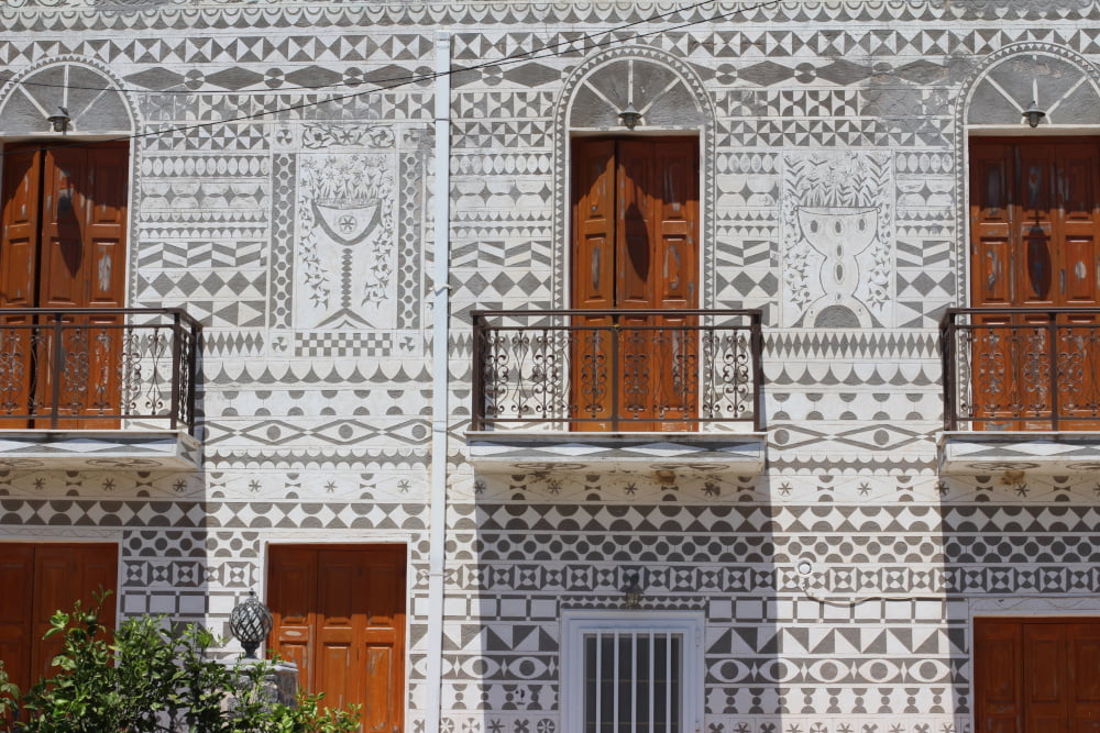 Destination Chion in the Aegean Sea featuring a traditional village where the houses are painted with black and white geometrical patterns by RentAGreekVilla powered by PathTravelDesigns Greece