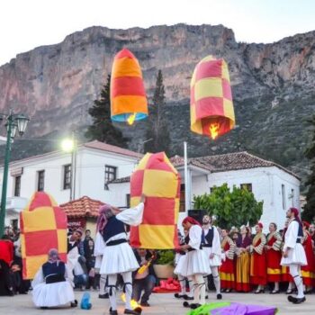 Leonidio paper lanterns | Easter in Greece Crowds have gathered in the main square of Leonidio in Greece to celebrate a traditional Greek Easter. Men wearing traditional Greek costumes are lighting and setting free paper lanterns. Women wearing traditional customs can be seen in the background. This is part of unoiqu local Greek customs found throughout Greece to celebrate Easter
