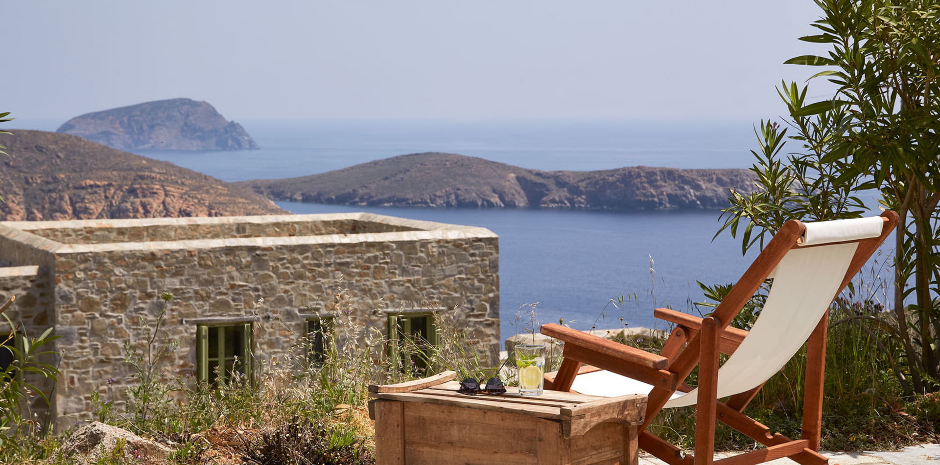 Serifos holiday villa terrace with Aegean sea view, stone architecture and sunlounger, Cyclades Greece